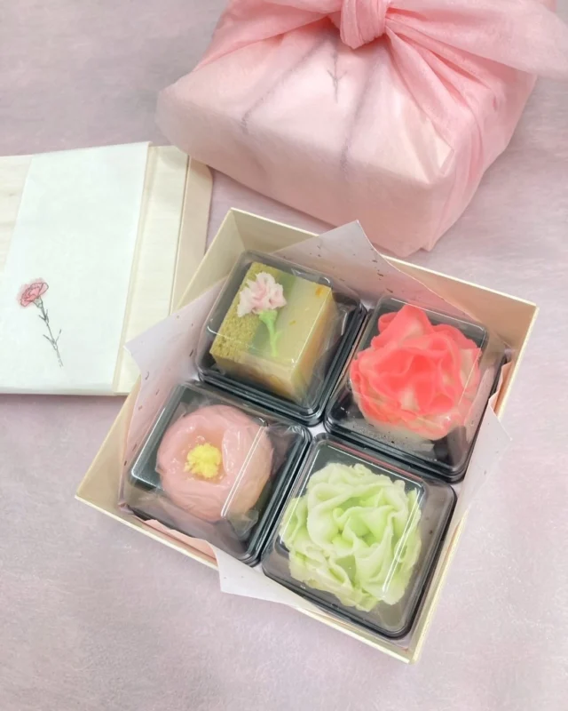 【母の日】  お花も好きだけど、甘いお菓子も好き。
そんなお母様に、あん味堂の花の和菓子を贈りませんか。  赤いカーネーションの練り切りは越後姫餡。  緑のカーネーションはこしあん。  「感謝」と名付けた四角いお菓子は
抹茶浮島、抹茶羊羹、清見オレンジ羊羹。  「山芍薬」は
外郎（ういろう）、柚子カシューナッツあん。  木の箱に入れて、風呂敷に包んでお渡しです。  これらのお菓子はお好きなお茶と一緒に
茶室で召し上がっていただくこともできます。  ぜひ、お母様とゆっくり語らうひとときを
多賀でお過ごしください。  母の日メッセージを書ける新茶のプレゼントもご用意しています。  この週末はぜひ、多賀茶焙煎所へ。
お待ちしています。  #多賀茶焙煎所 #tearoastery
#あん味堂 #いろり庵
#日本茶 #ほうじ茶 #自家焙煎 #和カフェ #和風 #甘味 #わらび餅 #和菓子
#新潟みやげ #せんべい
#日本茶カフェ #新潟カフェ #上越カフェ #上越スイーツ
#新潟 #上越 #高田
#japantravel #japantrip
#niigata #japan #joetsu #母の日 #カーネーション #山芍薬　#新茶